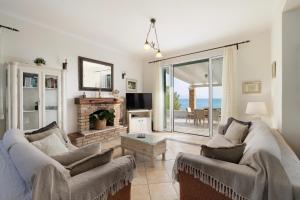 un soggiorno con due divani e un camino di Beachfront Villa Victoras - With private beach a Sidari