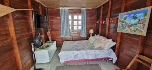 een kleine slaapkamer met een bed en een televisie bij Casa Flutuante em Manaus - Amazonas in Manaus