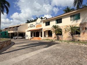 梅里达HOTEL A´PONTE的一座巨大的白色建筑，前面有棕榈树