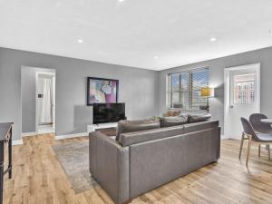 een woonkamer met een bank en een televisie bij World Cup Apartment Flat 10 to 14 Nights Premier Arena Location in Atlanta