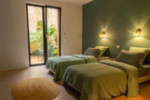 ein Schlafzimmer mit zwei Betten und einem großen Fenster in der Unterkunft Villa Les Restanques in Aix-en-Provence