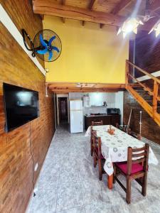 una sala da pranzo con un tavolo e una TV a parete di Cabañas La Carlota a Trapiche