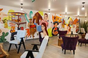 a room with chairs and a wall with a mural at La Casa del Mural - Suites Condesa in Mexico City +48 photos