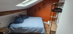 een slaapkamer met een bed met blauwe kussens bij Cozy Loft sous les toits in Le Kremlin-Bicêtre