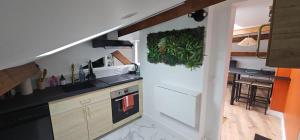 een keuken met een witte koelkast naast een aanrecht bij Cozy Loft sous les toits in Le Kremlin-Bicêtre