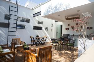 a patio with chairs and tables and a staircase at La Casa del Mural - Suites Condesa in Mexico City