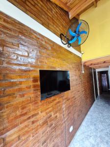 a brick wall with a tv on a wall at Cabañas La Carlota in Trapiche