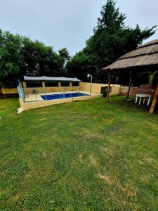 un edificio con piscina in un campo erboso di Cabañas La Carlota a Trapiche