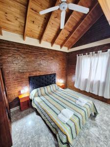 una camera da letto con un letto e un ventilatore a soffitto di Cabañas La Carlota a Trapiche