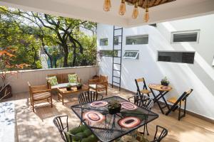 a patio with a table and chairs on a balcony at La Casa del Mural - Suites Condesa in Mexico City