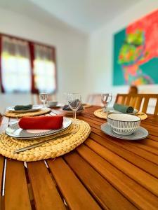 a wooden table with plates and wine glasses on it at La Case Auvergnate in Anse-Bertrand +12 photos