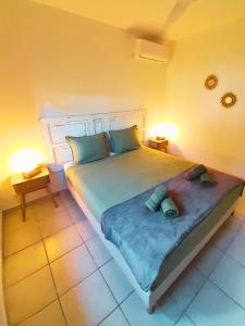 a bedroom with a large bed with two pillows at La Case Auvergnate in Anse-Bertrand