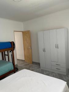 ein Schlafzimmer mit weißen Schränken, einem Bett und einer Tür in der Unterkunft Departamento NAMASTE I in Carhué