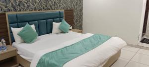 a bedroom with a bed with a blue headboard and pillows at Hotel Nest View In in Ahmedabad