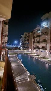 a swimming pool in front of some buildings at night at Kemet Apartment luxor in Luxor