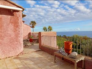 a patio with a table and a view of the ocean at Paradis bleu in Agay - Saint Raphael