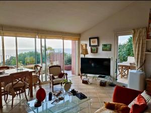 a living room with a table and a large screen tv at Paradis bleu in Agay - Saint Raphael