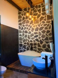 a bathroom with two sinks and a stone wall at Cábaña bonita vista in Atemajac de Brizuela +40 photos