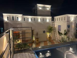 a building with a swimming pool in front of it at night at Villa Shakti - TIE Hotels in Pondicherry