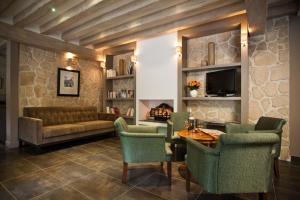 a living room with a couch and a table and chairs at Hôtel Du Printemps in Paris