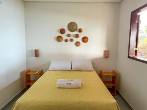 una stanza con un letto con sopra un copriletto giallo di Chalé Refúgio dos Corais 1 a Japaratinga