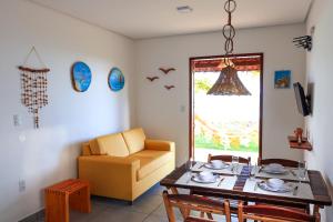 un soggiorno con tavolo e divano giallo di Chalé Refúgio dos Corais 1 a Japaratinga