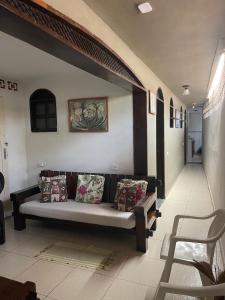 a living room with a couch with pillows on it at Raízes Pousada in Porto Seguro +97 photos