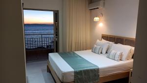 a bedroom with a bed with a view of the ocean at Thassos Hotel in Pefkari