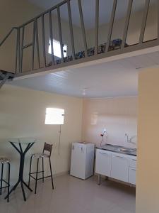 a kitchen with a table and a staircase in the ceiling at Loft confortável in Morro do Chapéu