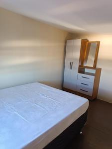a bedroom with a bed and a dresser and a mirror at Loft confortável in Morro do Chapéu