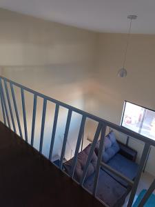 a room with a staircase with a bed and a television at Loft confortável in Morro do Chapéu +1 photo