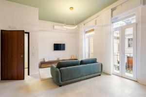 a living room with a blue couch and a television at Living Calabriando in Reggio di Calabria