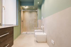 a bathroom with a shower and a toilet and a sink at Living Calabriando in Reggio di Calabria +23 photos