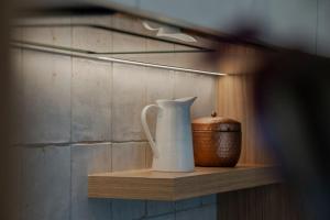 Ein weißer Krug und eine Schüssel auf einem Holzregal in der Unterkunft Central City Queenstown Retreat - 3 Bedroom Apartment in Queenstown