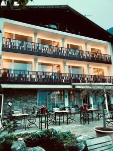 a building with tables and chairs in front of it at Hotel Braunsbergerhof in Lana