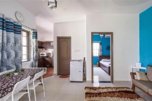een keuken en een woonkamer met een tafel en een koelkast bij Paradise Pool Villa 30min from Ecity Garden2BHK in Hosūr