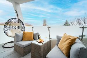 a patio with two wicker chairs and a table at New Modern Home-Projector-Nespresso-View-Balcony in Komárov