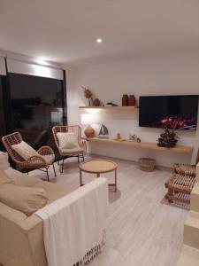 a living room with a couch and chairs and a flat screen tv at Senderos del Mar in Monte Hermoso