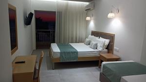 a hotel room with a bed and a desk and a room at Thassos Hotel in Pefkari