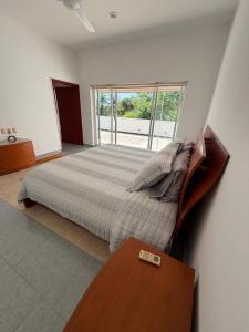 a bedroom with a bed with a table and a window at Casa Vemisa Puerto Escondido in Puerto Escondido +21 photos