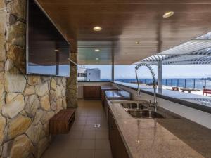 een keuken met een wastafel en een stenen muur bij Hotel Camarote Salvador in Salvador