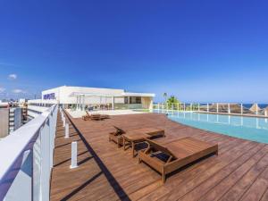 a deck with tables and chairs on the roof of a building at Hotel Camarote Salvador in Salvador