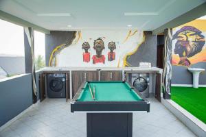 einen Billardtisch in einem Zimmer mit Gemälde in der Unterkunft Georgina's Court in Trofwi