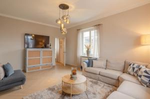ein Wohnzimmer mit Sofa und Tisch in der Unterkunft Villa Vulkaneifel in Kelberg