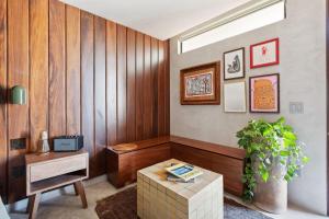 a living room with a table and a plant at ALMA Surf Lodge in Punta Mita