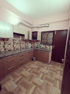 eine große Küche mit Holzboden und -schränken sowie einer Tür in der Unterkunft Geeta's Luxuria in Varanasi