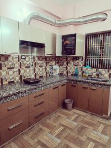 eine Küche mit Holzschränken und Granitarbeitsflächen in der Unterkunft Geeta's Luxuria in Varanasi