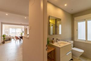 a bathroom with a sink and a toilet and a dining room at Concepcion Suite in Córdoba
