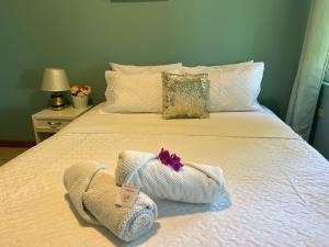 Una cama con dos toallas encima en Family Stay con Desayuno 7 camas 6 dormitorios, en Puyo