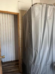 einen Duschvorhang in einem Zimmer neben einer Tür in der Unterkunft Hospedaje La Cascada in Futaleufú